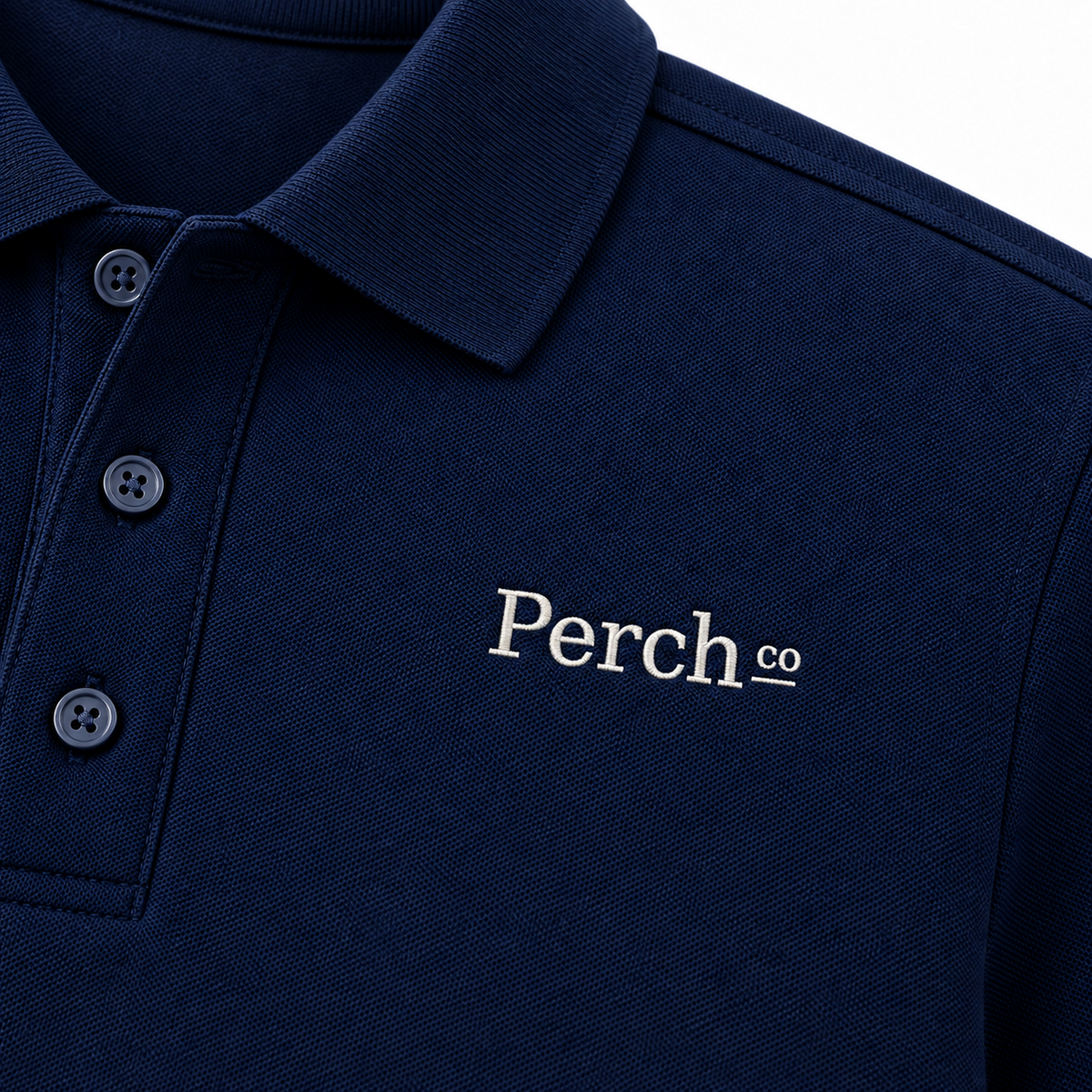 Close-up of the embroidered logo and ribbed collar on the polo shirt