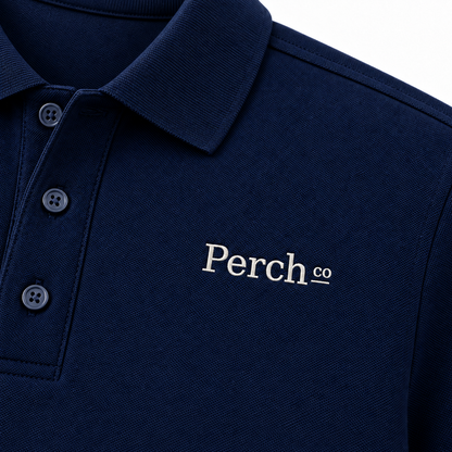 Close-up of the embroidered logo and ribbed collar on the polo shirt