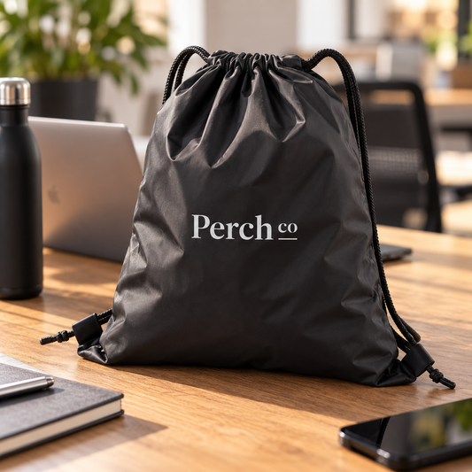 Branded black drawstring bag on an office desk