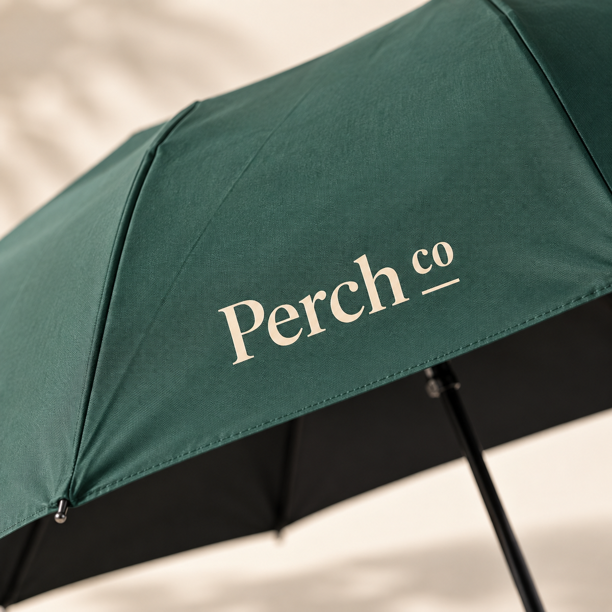 Close-up of the printed logo on the green umbrella canopy