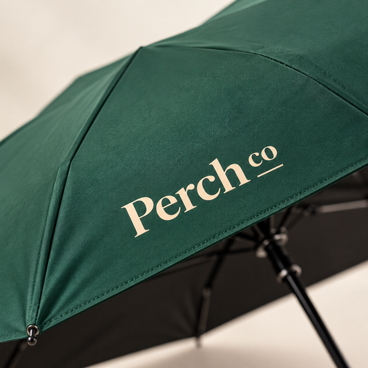Close-up of the printed logo on the green canopy of the wooden-handle umbrella