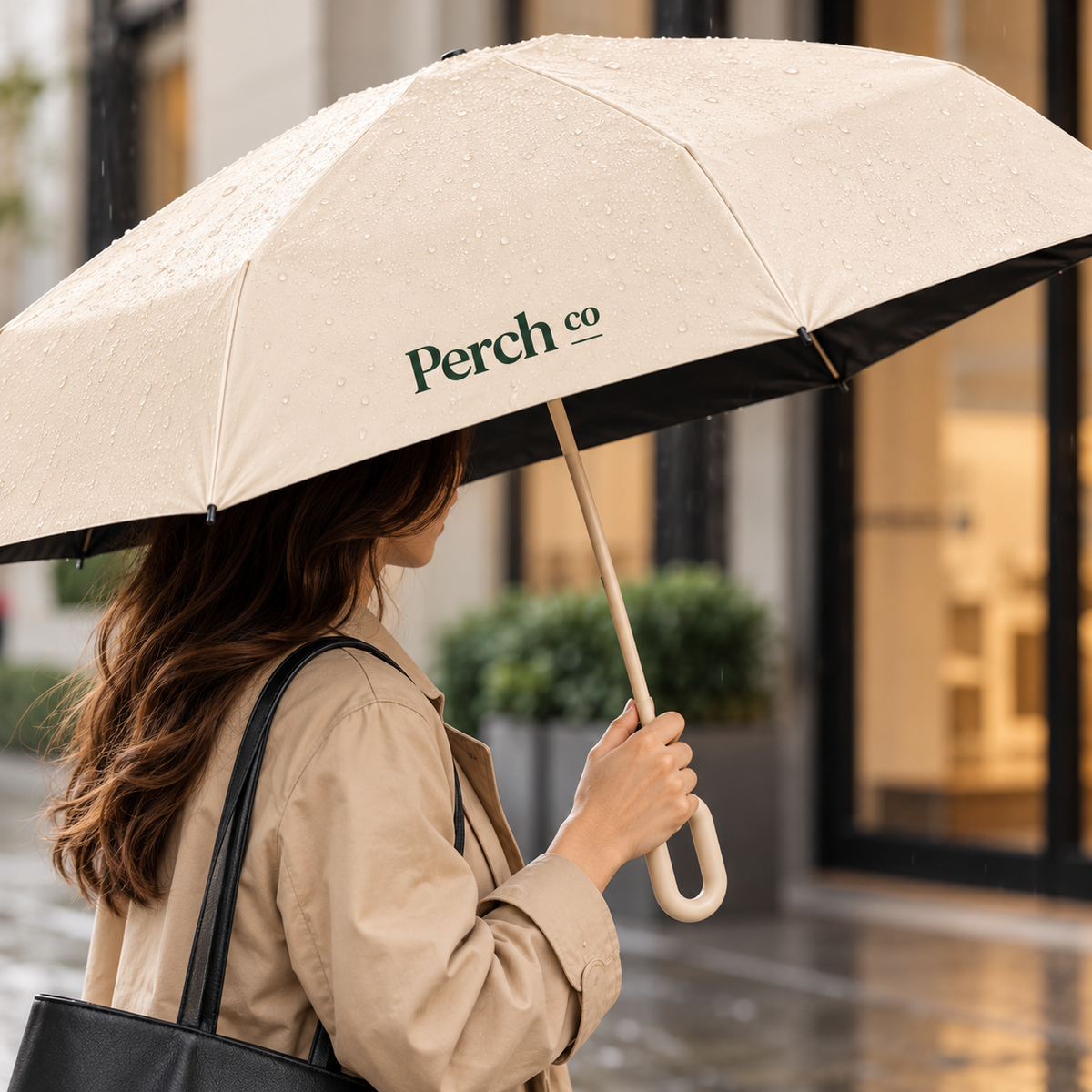 Loop-handle umbrella in use in the rain, with a printed logo on the canopy