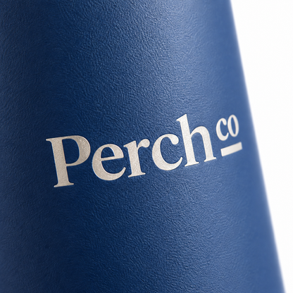 Close-up of a printed logo on the matte navy body of the bamboo lid water bottle