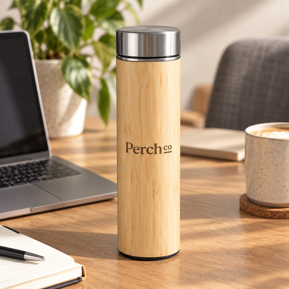 Perch Co branded slim bamboo flask on a desk beside a laptop and coffee