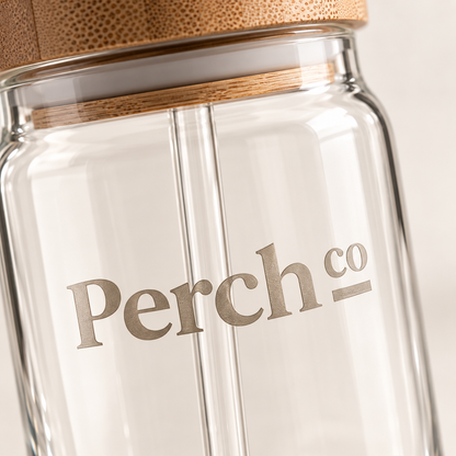 Close-up of the Perch Co logo on a glass can tumbler with a bamboo lid and seal ring