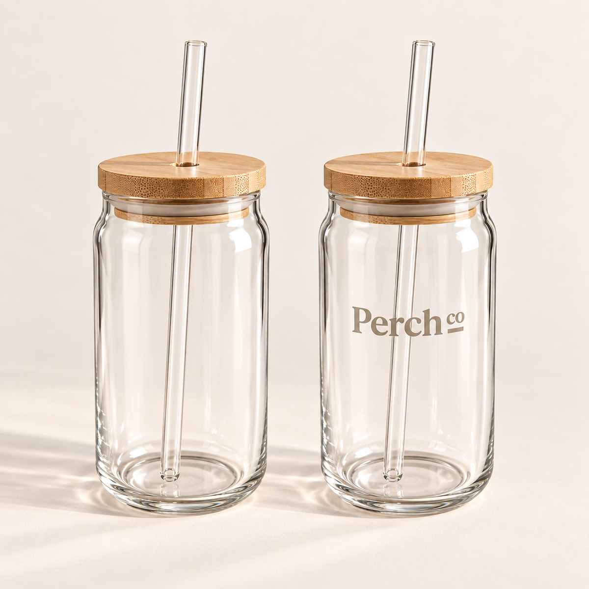 Two glass can tumblers with bamboo lids and glass straws, one branded with the Perch Co logo