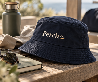 Detail of the embroidered logo and topstitched brim on the navy bucket hat