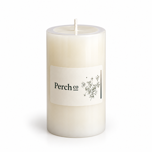 Single ivory pillar candle with a branded wrap label, flat top and single wick