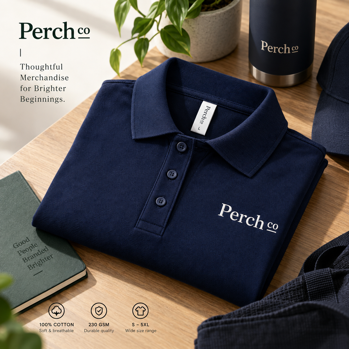Folded navy polo shirt on a desk with a notebook and bottle
